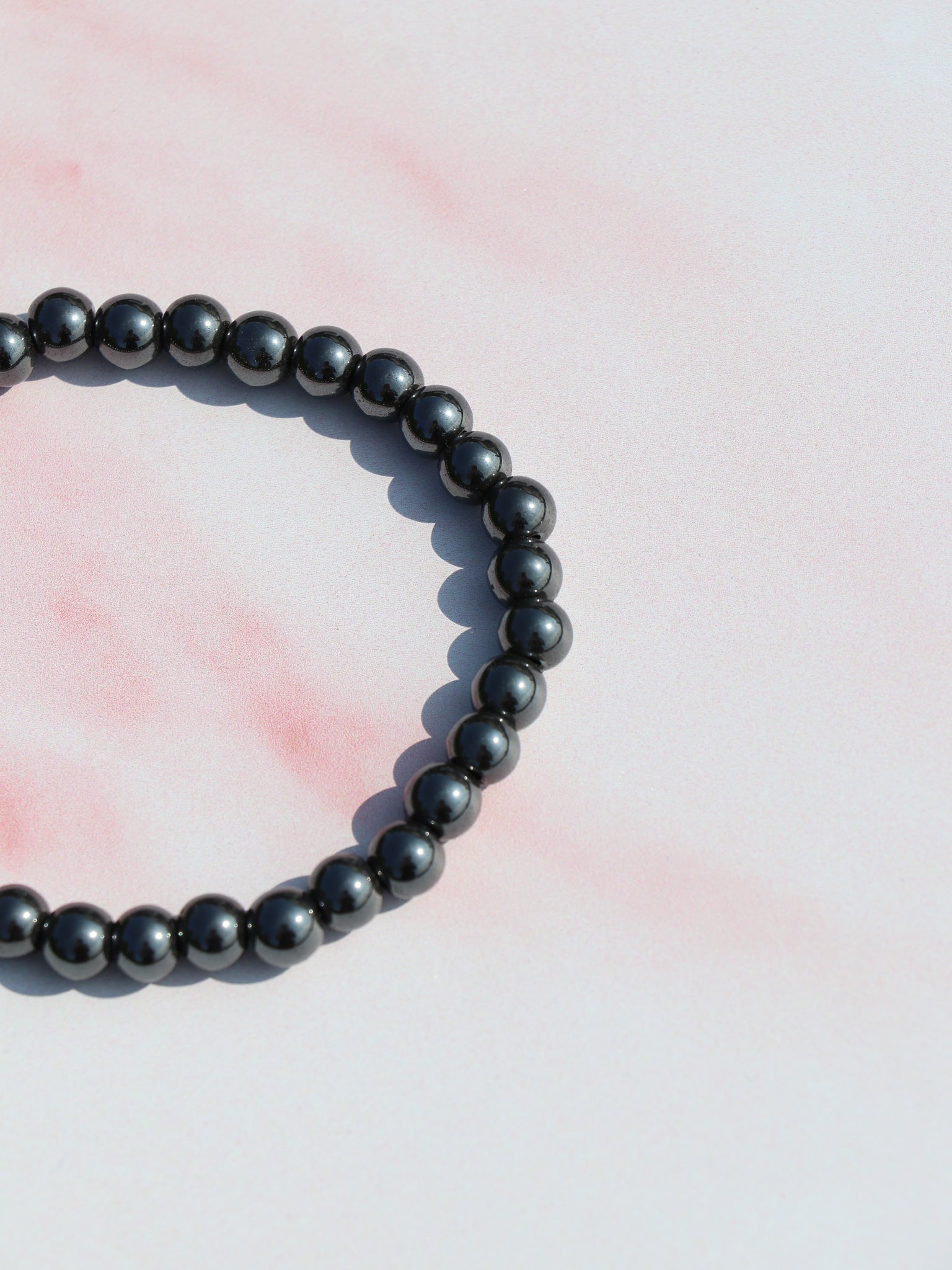 Hæmatit armbånd med blank, metallisk glans. Kendt for jordforbindelse, beskyttelse og styrkelse af selvtillid.