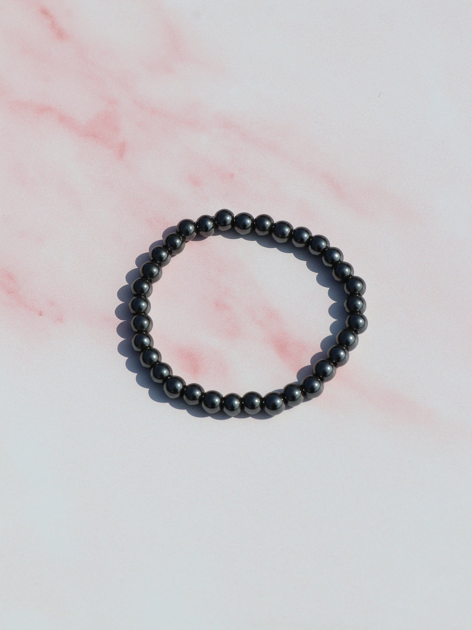 Hæmatit armbånd med blank, metallisk glans. Kendt for jordforbindelse, beskyttelse og styrkelse af selvtillid.