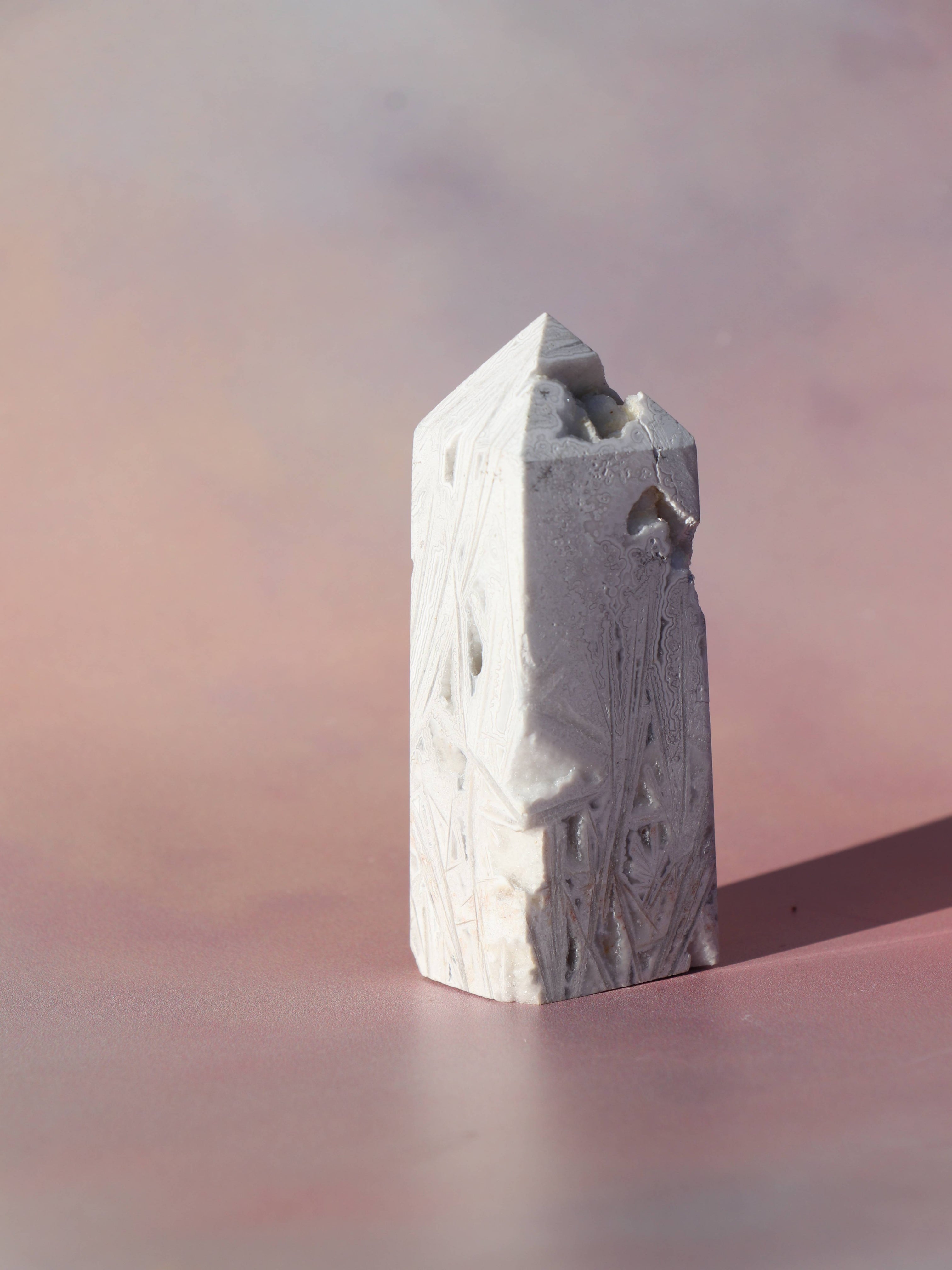 White Lace Agat er en smuk, hvid sten med fine bånd, der bringer ro og klarhed til sindet. Den støtter dig i følelsesmæssig balance, indre fred og selvaccept. Brug den til meditation, stresslindring eller som støtte i svære perioder. En perfekt krystal til dig, der ønsker mere lys og lethed i hverdagen.