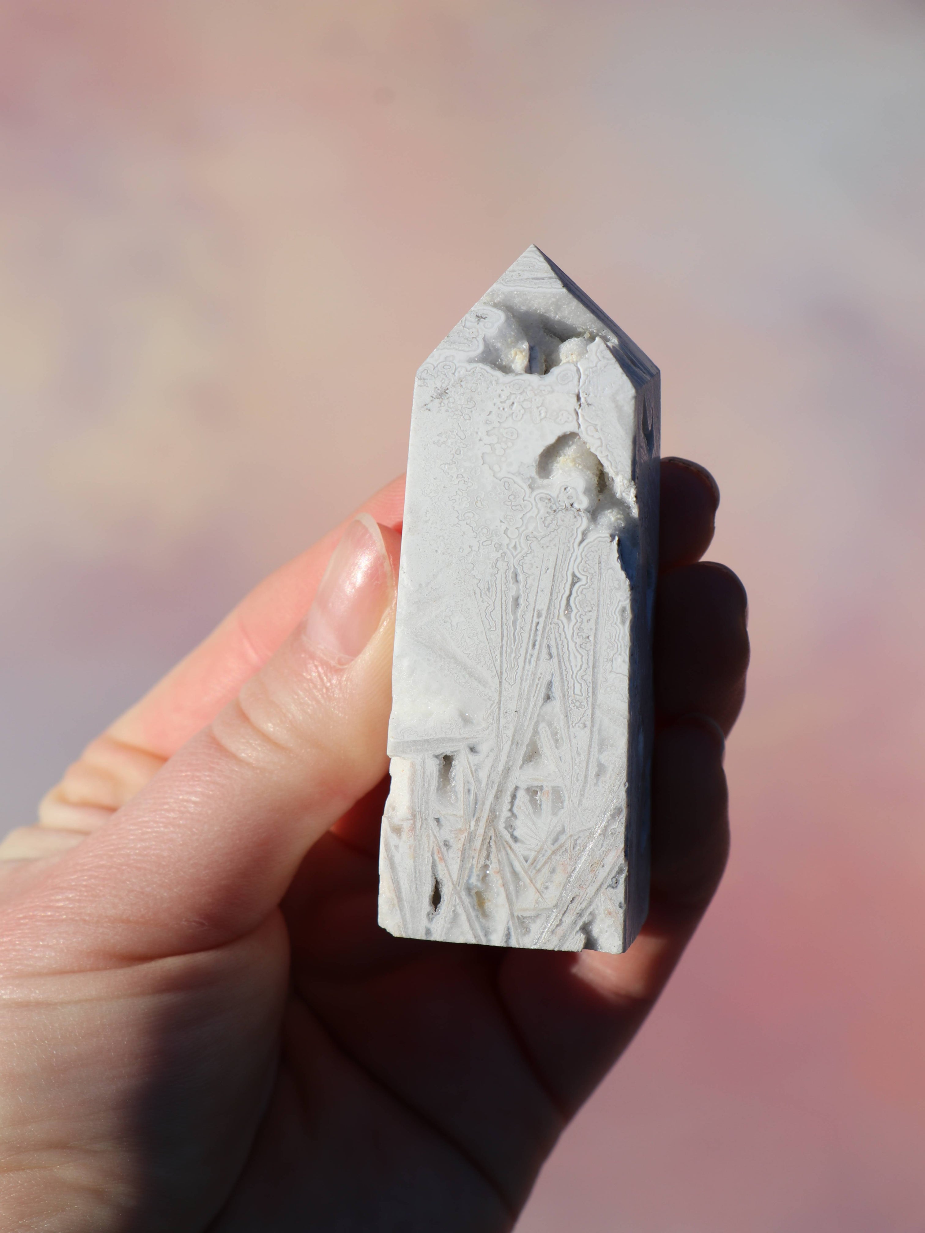 White Lace Agat er en smuk, hvid sten med fine bånd, der bringer ro og klarhed til sindet. Den støtter dig i følelsesmæssig balance, indre fred og selvaccept. Brug den til meditation, stresslindring eller som støtte i svære perioder. En perfekt krystal til dig, der ønsker mere lys og lethed i hverdagen.