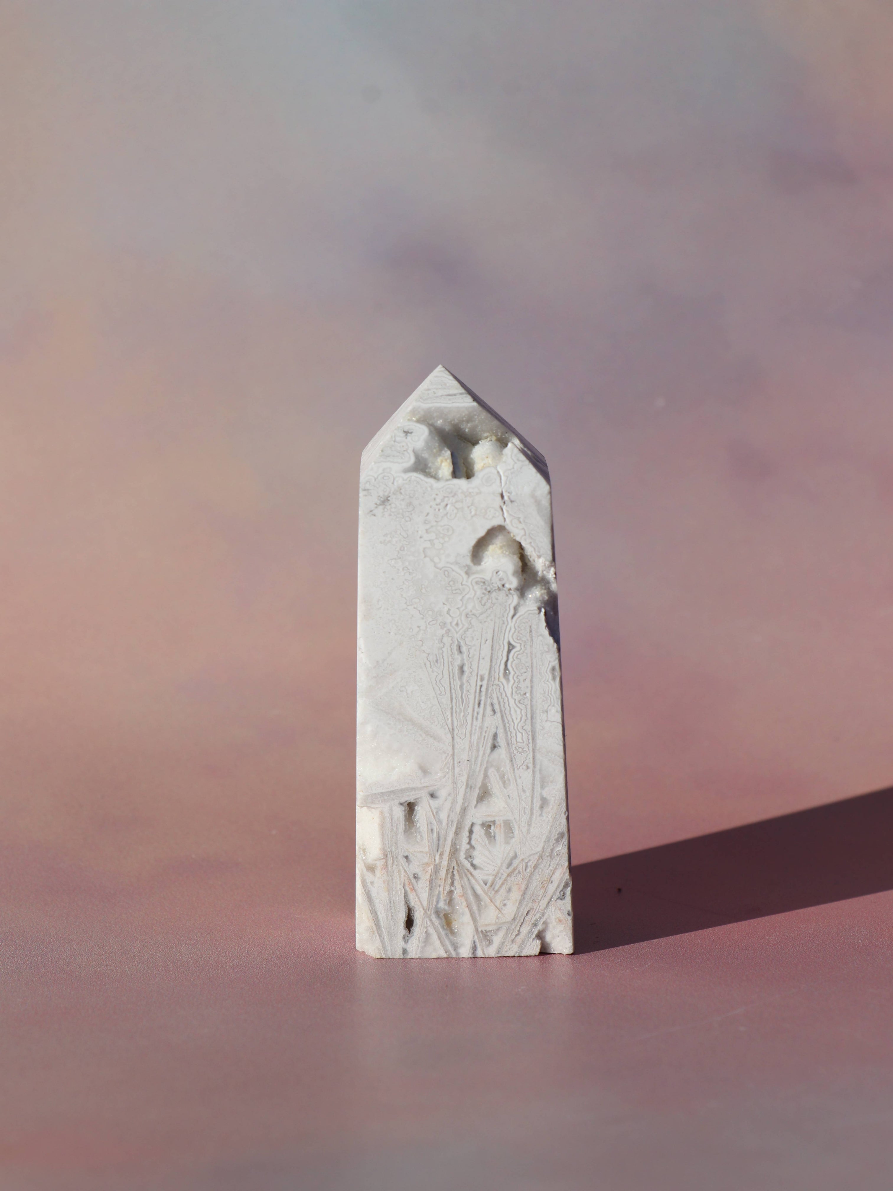 White Lace Agat er en smuk, hvid sten med fine bånd, der bringer ro og klarhed til sindet. Den støtter dig i følelsesmæssig balance, indre fred og selvaccept. Brug den til meditation, stresslindring eller som støtte i svære perioder. En perfekt krystal til dig, der ønsker mere lys og lethed i hverdagen.