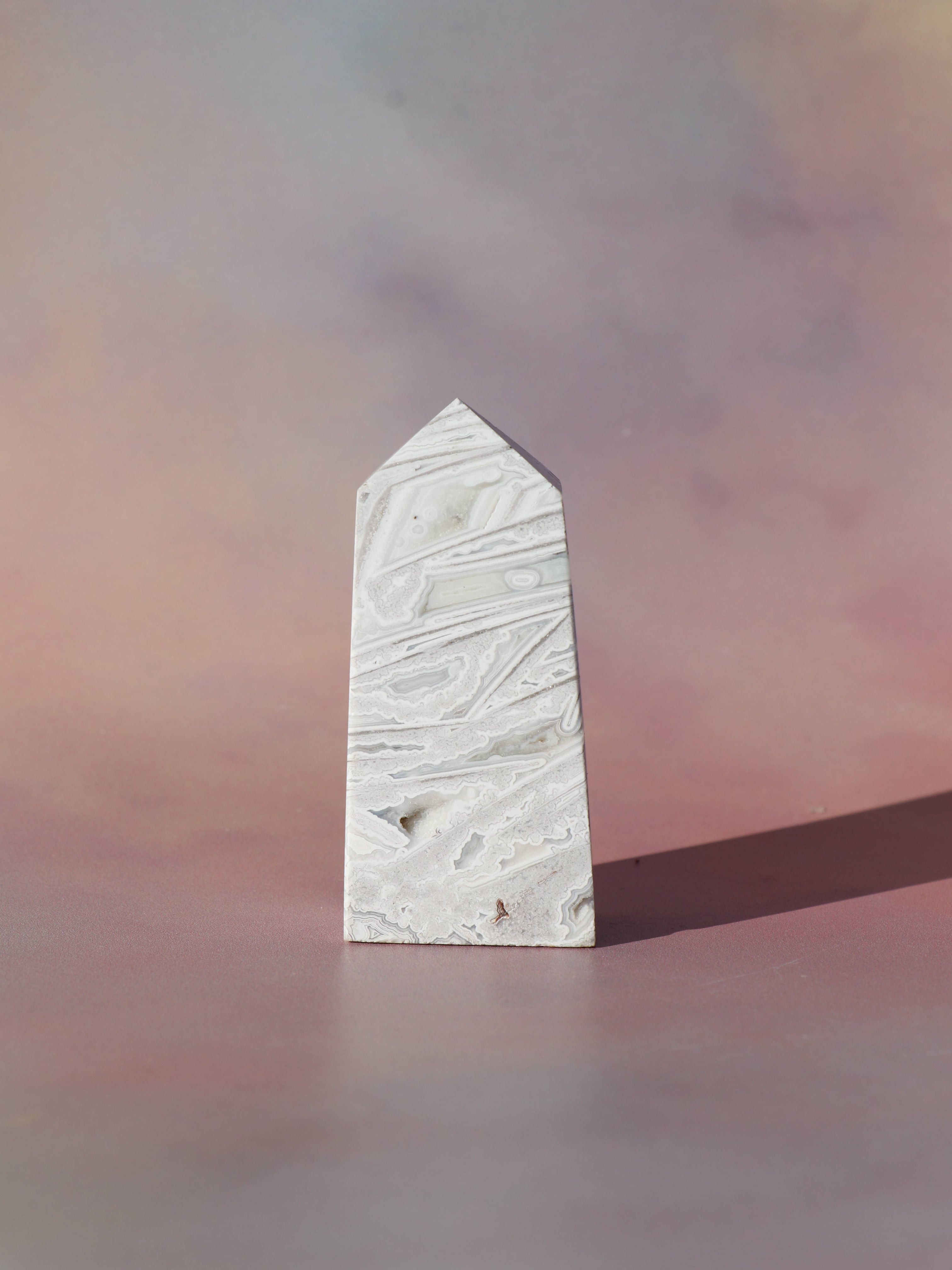 White Lace Agat er en smuk, hvid sten med fine bånd, der bringer ro og klarhed til sindet. Den støtter dig i følelsesmæssig balance, indre fred og selvaccept. Brug den til meditation, stresslindring eller som støtte i svære perioder. En perfekt krystal til dig, der ønsker mere lys og lethed i hverdagen.