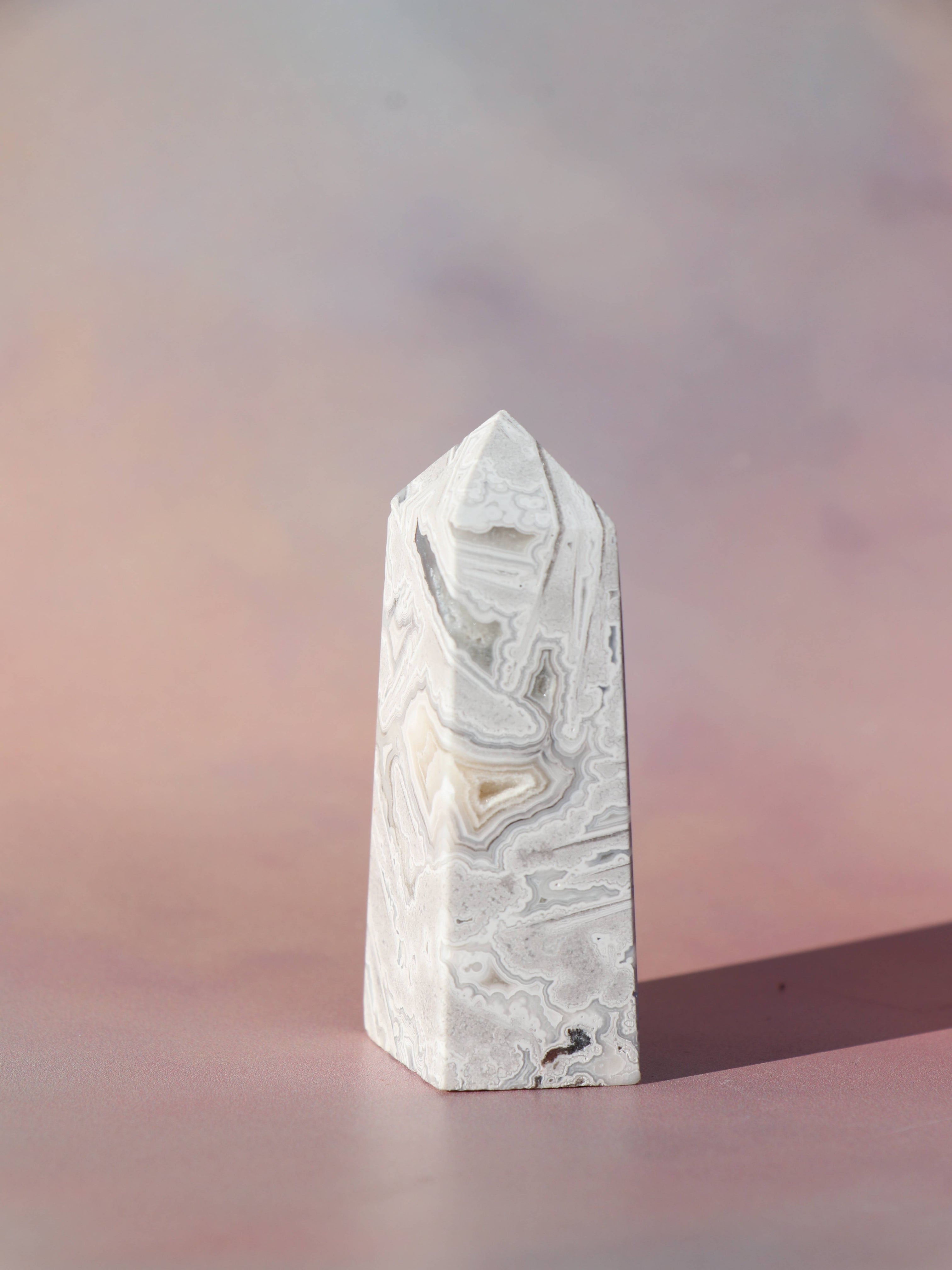 White Lace Agat er en smuk, hvid sten med fine bånd, der bringer ro og klarhed til sindet. Den støtter dig i følelsesmæssig balance, indre fred og selvaccept. Brug den til meditation, stresslindring eller som støtte i svære perioder. En perfekt krystal til dig, der ønsker mere lys og lethed i hverdagen.