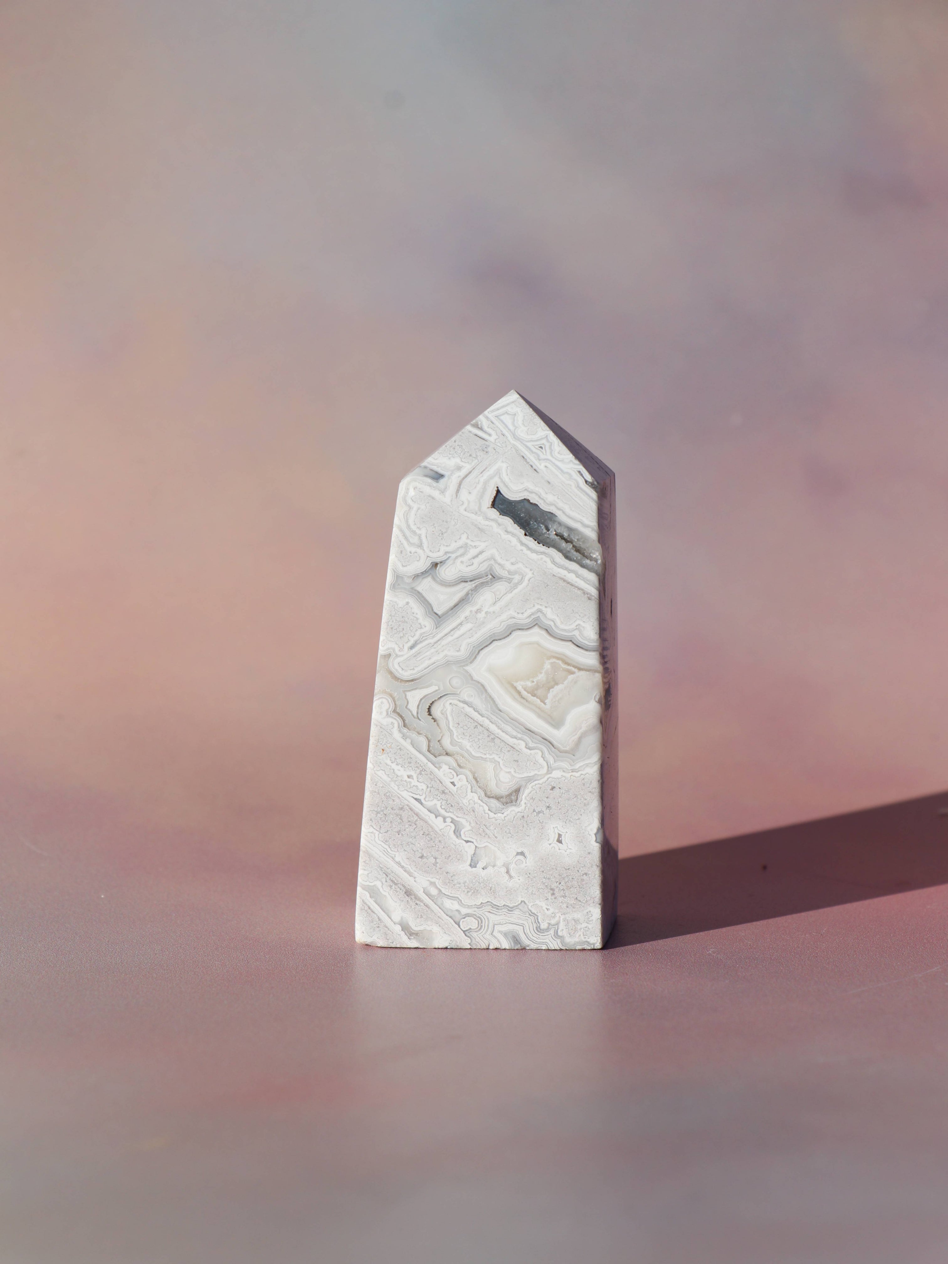 White Lace Agat er en smuk, hvid sten med fine bånd, der bringer ro og klarhed til sindet. Den støtter dig i følelsesmæssig balance, indre fred og selvaccept. Brug den til meditation, stresslindring eller som støtte i svære perioder. En perfekt krystal til dig, der ønsker mere lys og lethed i hverdagen.