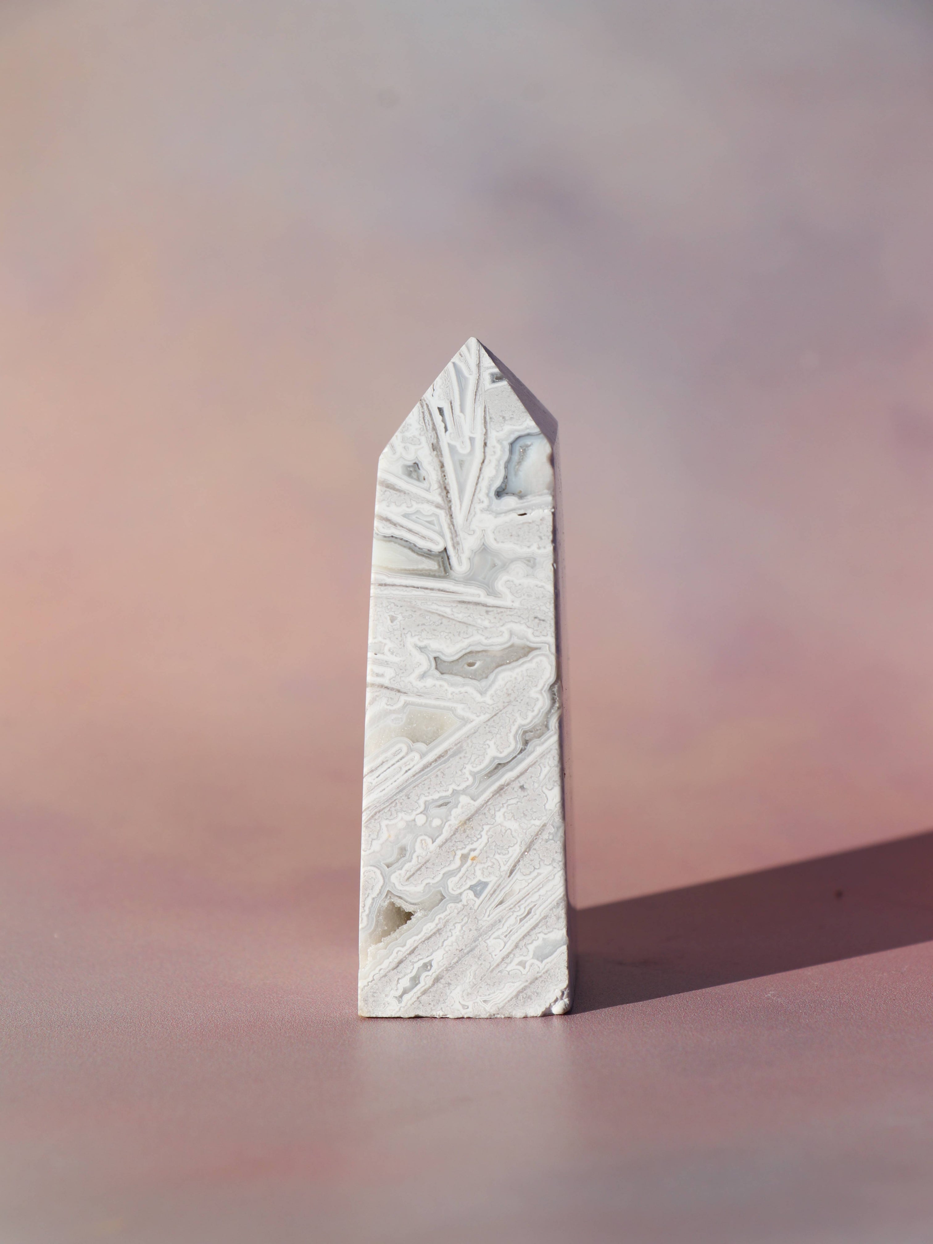 White Lace Agat er en smuk, hvid sten med fine bånd, der bringer ro og klarhed til sindet. Den støtter dig i følelsesmæssig balance, indre fred og selvaccept. Brug den til meditation, stresslindring eller som støtte i svære perioder. En perfekt krystal til dig, der ønsker mere lys og lethed i hverdagen.