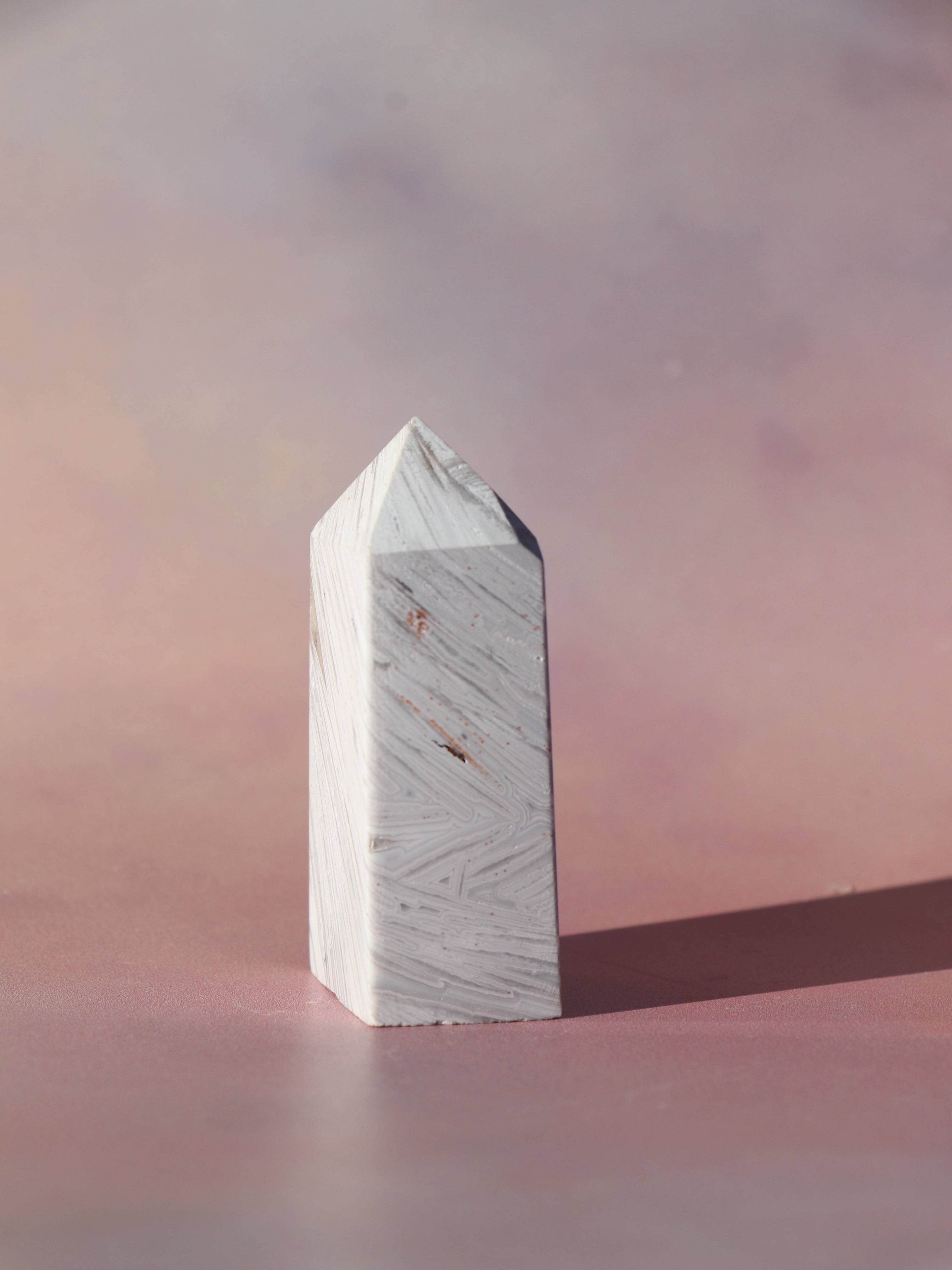 White Lace Agat er en smuk, hvid sten med fine bånd, der bringer ro og klarhed til sindet. Den støtter dig i følelsesmæssig balance, indre fred og selvaccept. Brug den til meditation, stresslindring eller som støtte i svære perioder. En perfekt krystal til dig, der ønsker mere lys og lethed i hverdagen.