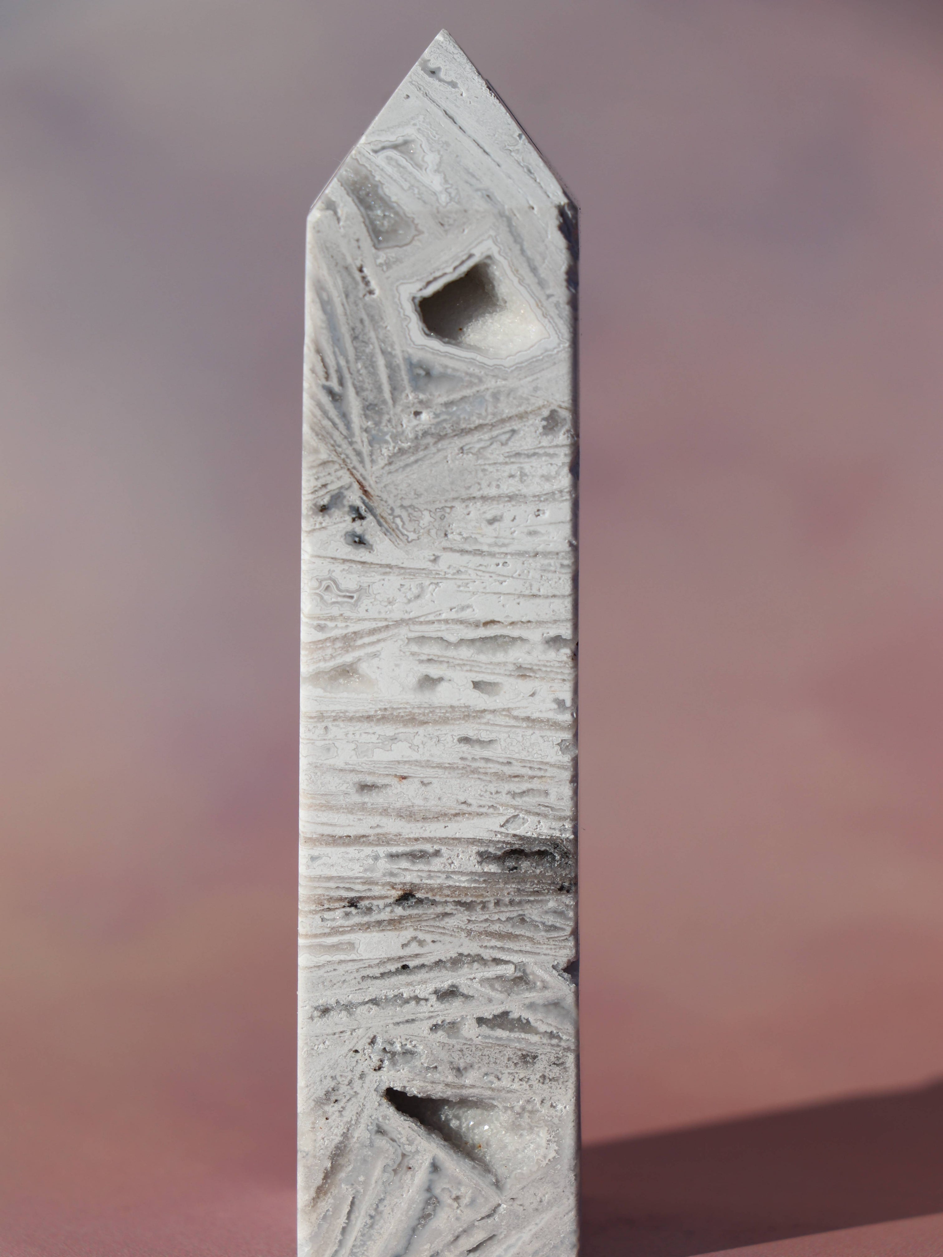 White Lace Agat er en smuk, hvid sten med fine bånd, der bringer ro og klarhed til sindet. Den støtter dig i følelsesmæssig balance, indre fred og selvaccept. Brug den til meditation, stresslindring eller som støtte i svære perioder. En perfekt krystal til dig, der ønsker mere lys og lethed i hverdagen.