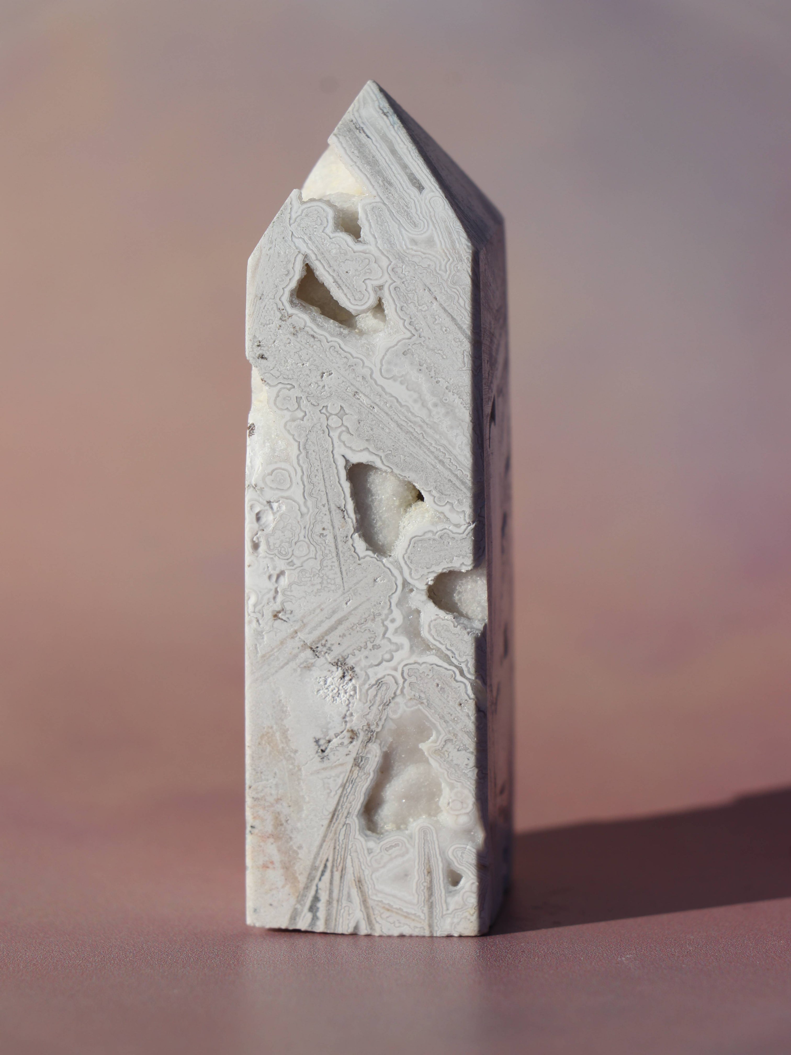 White Lace Agat er en smuk, hvid sten med fine bånd, der bringer ro og klarhed til sindet. Den støtter dig i følelsesmæssig balance, indre fred og selvaccept. Brug den til meditation, stresslindring eller som støtte i svære perioder. En perfekt krystal til dig, der ønsker mere lys og lethed i hverdagen.