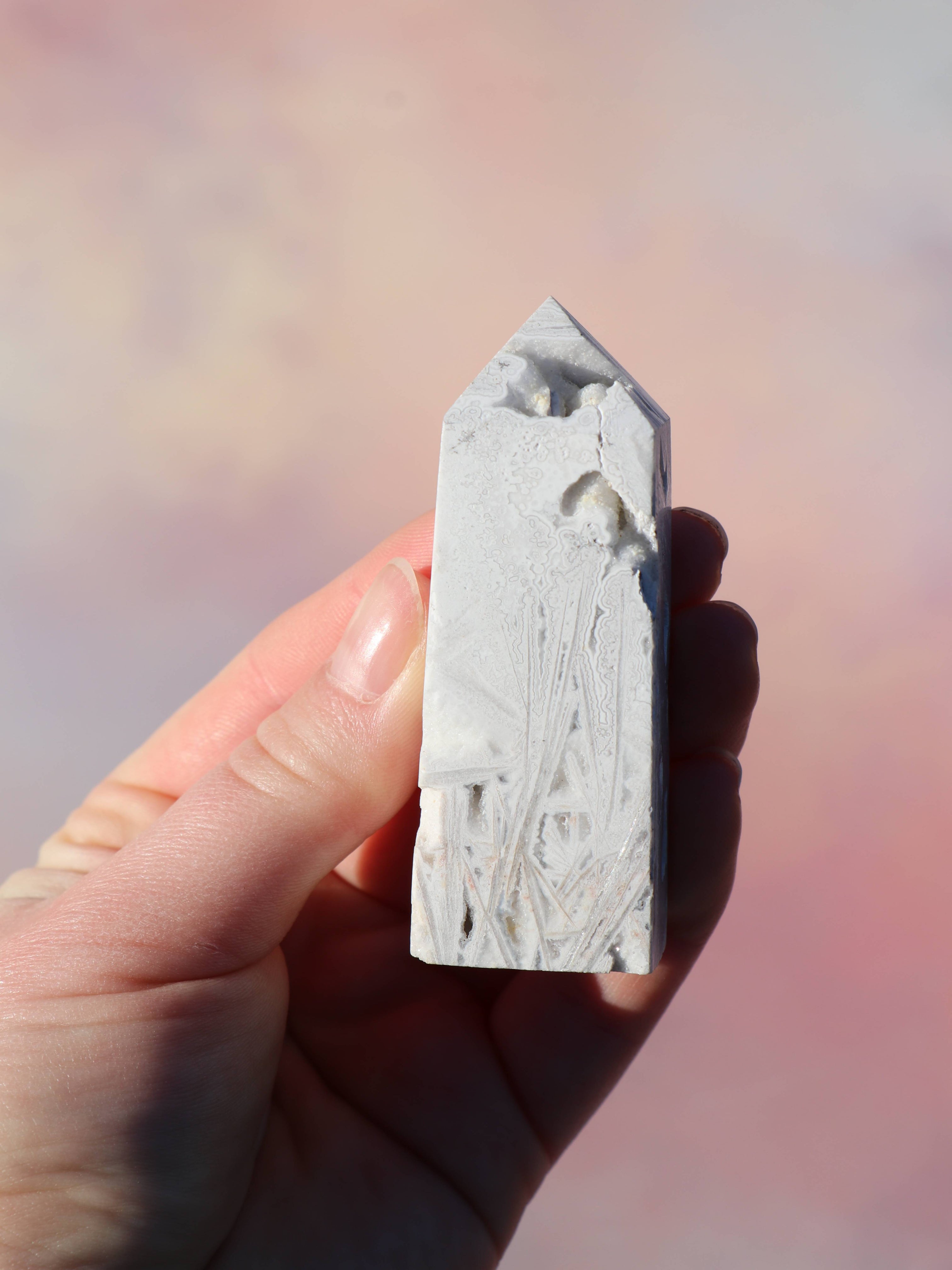 White Lace Agat er en smuk, hvid sten med fine bånd, der bringer ro og klarhed til sindet. Den støtter dig i følelsesmæssig balance, indre fred og selvaccept. Brug den til meditation, stresslindring eller som støtte i svære perioder. En perfekt krystal til dig, der ønsker mere lys og lethed i hverdagen.