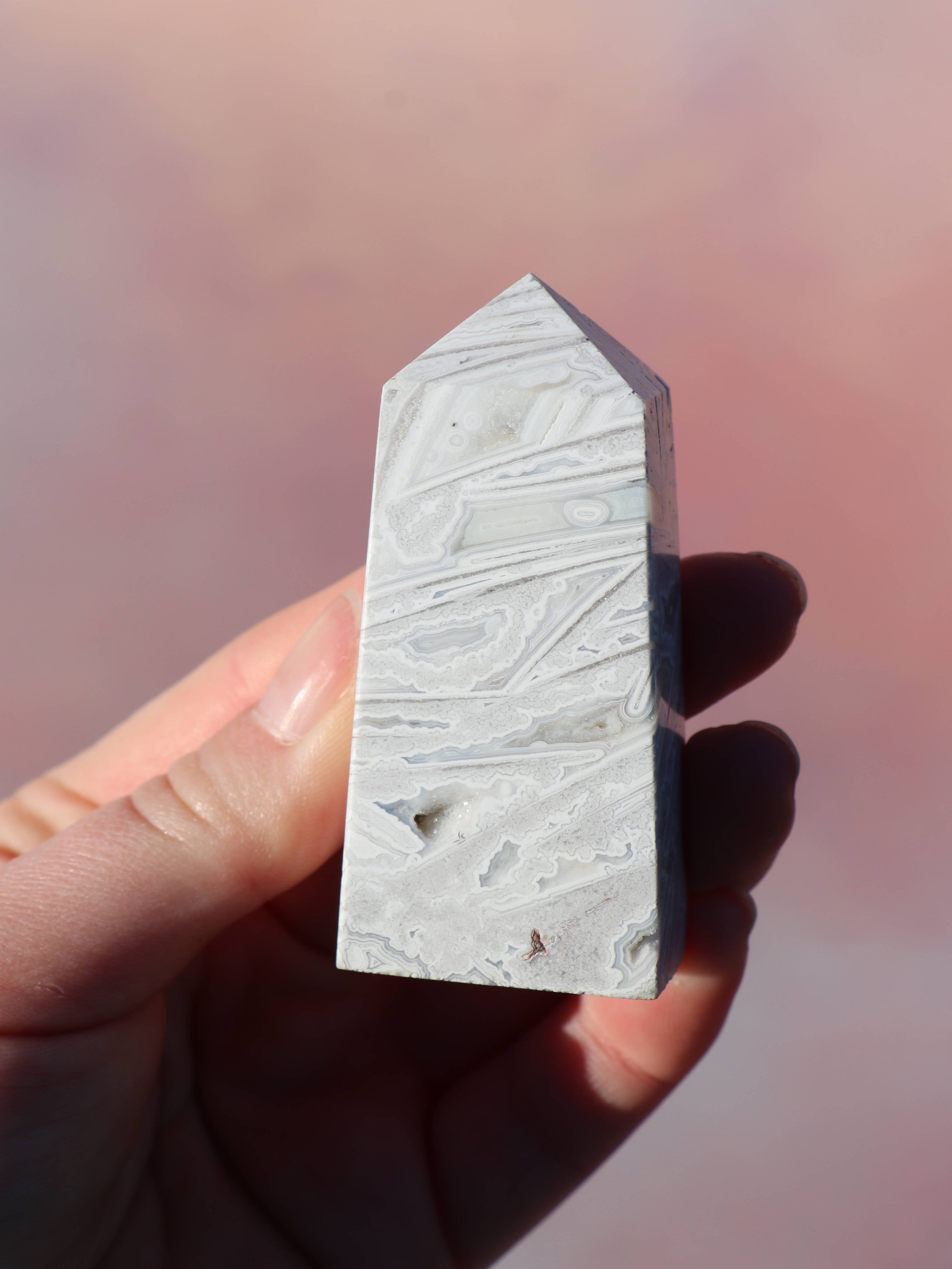 White Lace Agat er en smuk, hvid sten med fine bånd, der bringer ro og klarhed til sindet. Den støtter dig i følelsesmæssig balance, indre fred og selvaccept. Brug den til meditation, stresslindring eller som støtte i svære perioder. En perfekt krystal til dig, der ønsker mere lys og lethed i hverdagen.