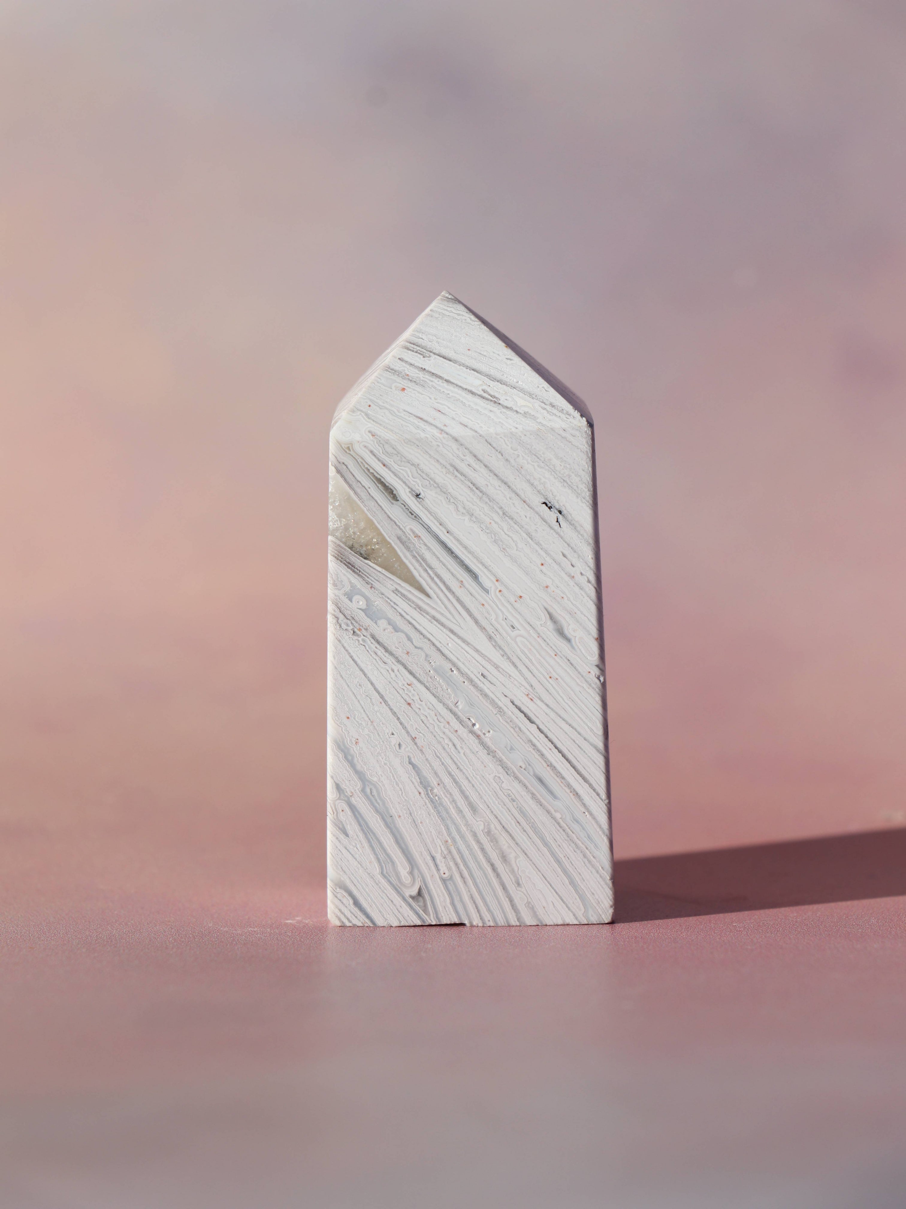 White Lace Agat er en smuk, hvid sten med fine bånd, der bringer ro og klarhed til sindet. Den støtter dig i følelsesmæssig balance, indre fred og selvaccept. Brug den til meditation, stresslindring eller som støtte i svære perioder. En perfekt krystal til dig, der ønsker mere lys og lethed i hverdagen.